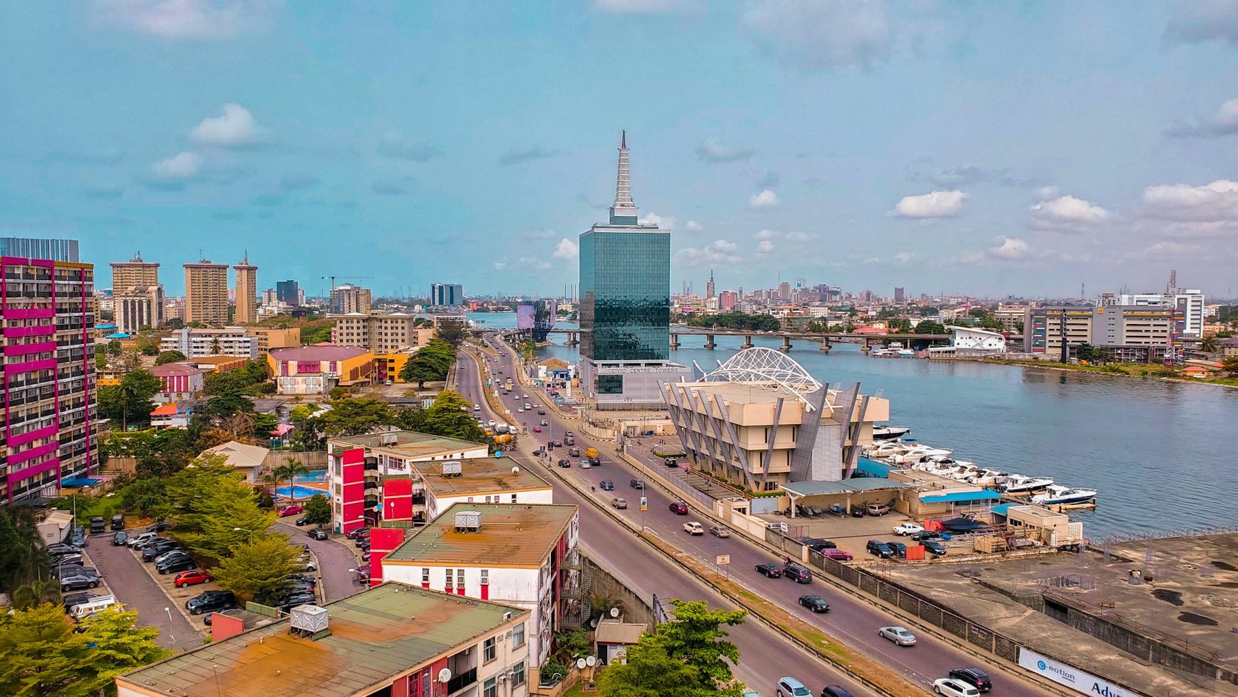 Aerial view of a Nigerian city waterfront and highway at midday