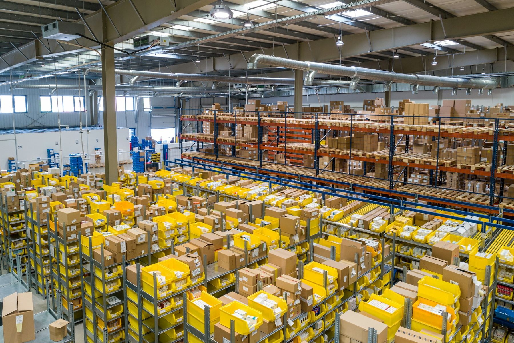 A large distribution warehouse with racked inventory and yellow crates